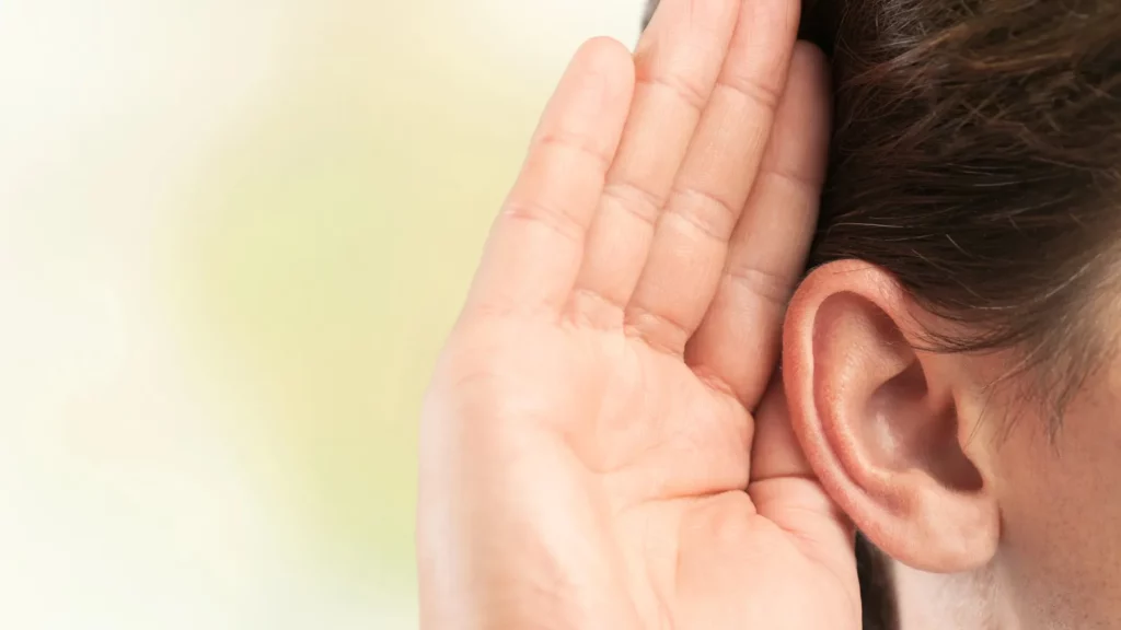 Businessman holds his hand near ear
