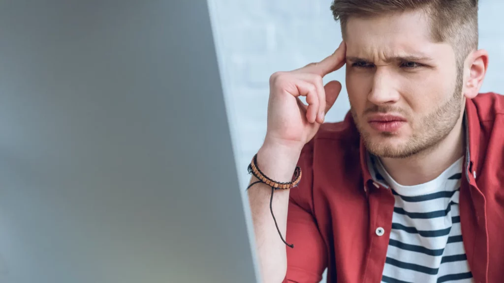 confused man looking at computer screen
