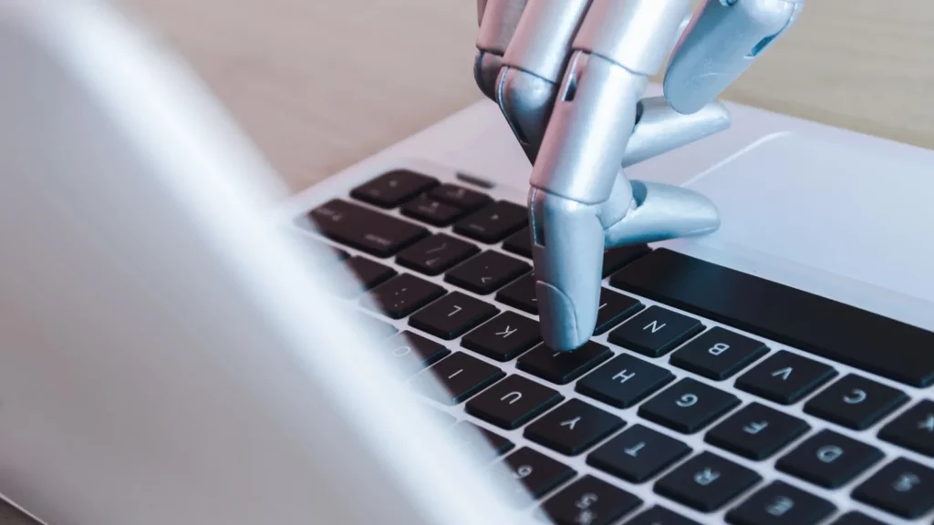 robot hands and fingers point to laptop button advisor chatbot